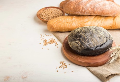 Different kinds of fresh baked bread on a white wooden background. side view, close up, copy space