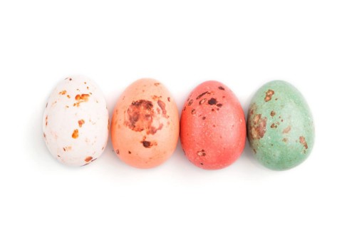 Four chocolate eggs candies isolated on white background. close up, top view, flat lay