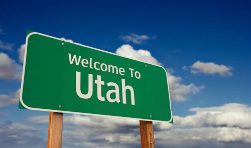 Welcome to utah green road sign over blue sky with some clouds