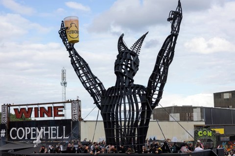 Copenhagen, Denmark - 19 June 2024: Festivalgoers in front of the logo at the Copenhell Metal