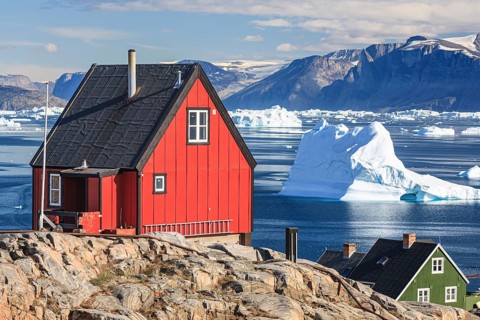 Typical Greenlandic houses in front of icebergs, Inuit settlement, summer, sunny, Uummannaq, West