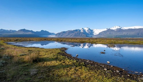 Lake with reflection, view of glacier tongues Skaftafellsjökull and Svínafellskökull, glaciated