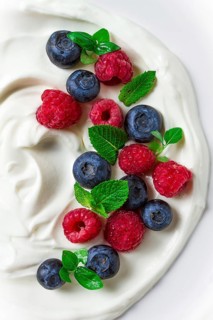 Breakfast, yogurt with fresh berries, raspberries and blueberries, on a white background, selective