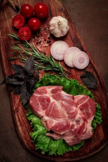 Raw pork steak, two pieces, on a wooden background