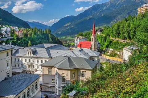 View of the village with Grandhotel Straubinger by the waterfall and parish church, Bad Gastein,