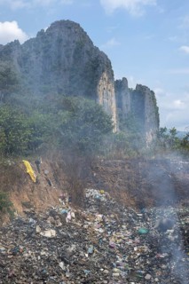 Coking rubbish dump, rubbish pit with waste and plastic rubbish, karst landscape near Vang Vieng,