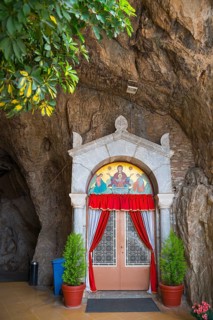 Sanctuary entrance in rock face, red curtains, religious icons, Church of Mary the Fountain of