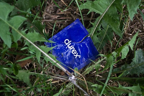 Open condom sachet dumped in nature, France, Europe