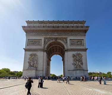 Front view of the Arc de Triomphe, people walking under the sunny sky, Paris