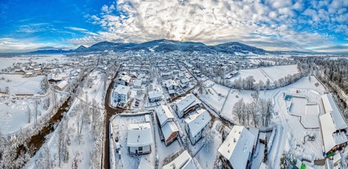 Panorama of a snow-covered village from a bird's eye view under a blue sky, Bad Feilnbach
