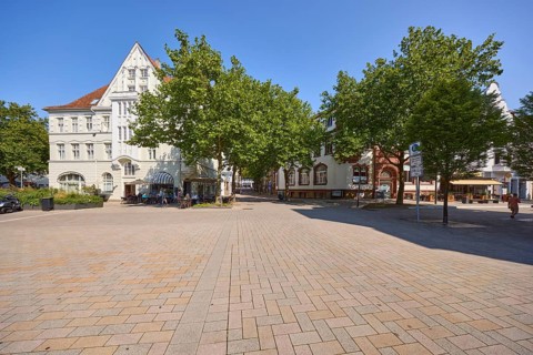 Historic residential building with trees at the intersection of Steege and Am Markt street in Bad