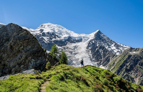 Mountaineer on a hiking trail in front of mountain landscape with glacier, view of glacier Glacier
