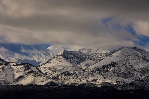 Snow-covered mountains in winter under a cloudy and overcast sky, Lefka Ori, White Mountains,