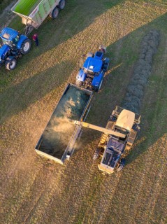 Aerial view of two tractors and a trailer during field work at the harvest, Haselstaller Hof,