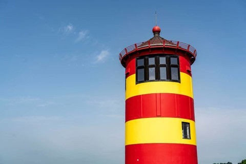 The Pilsum lighthouse on the North Sea dyke near Greetsiel, East Frisia, Lower Saxony, Germany,