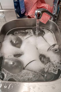 Kitchen after a big dinner, cooking party, sink with dirty glasses, sink
