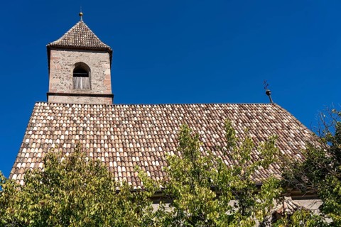 Church in the village of Montiggl, colourful shingle roof, on the South Tyrolean Wine Road, near