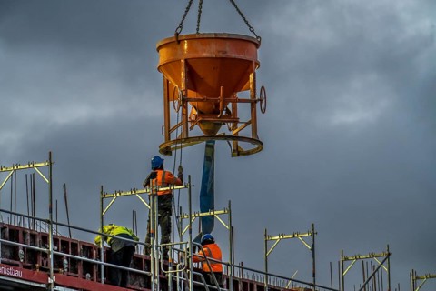 Concrete work, at dusk, on a large construction site building a residential and commercial complex,