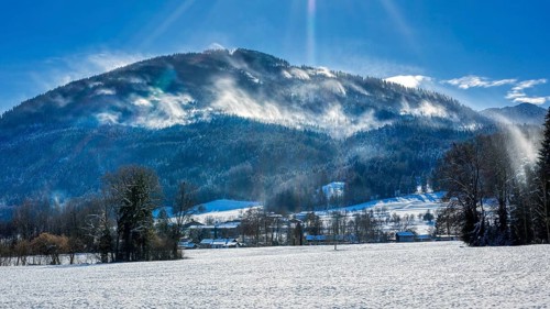 Snowy winter landscape with mountains in the background and sunny sky, Bad Feilnbach