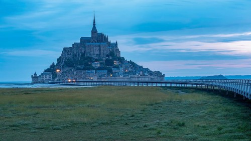 Mont Saint Michel in front of sunrise, rocky monastery island in the Wadden Sea, Le Mont Saint