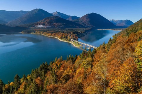 Aerial view of a mountain lake and autumnal coloured trees in the morning light, Sylvensteinsee,