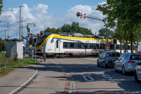 Regional train crossing a level crossing with barriers, Riegel am Kaiserstuhl, Baden-Württemberg,