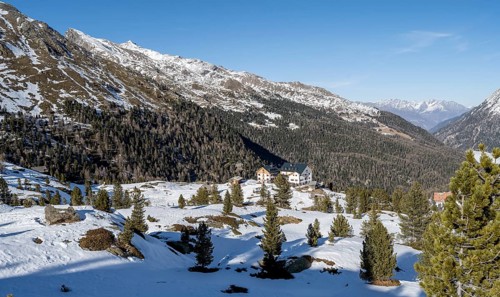 Zufallhütte mountain hut, view of the Martell Valley, snow-covered mountain landscape in winter,