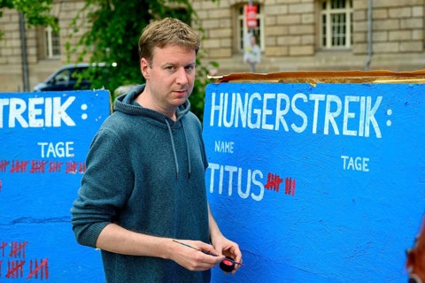 Titus Feldmann marks the 8th day of his hunger strike on a large board. Hunger strike camp,
