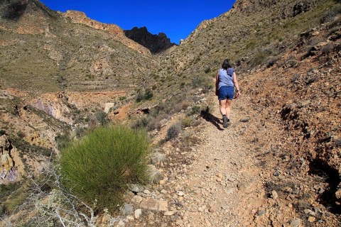 Woman walking Ruta del Agua to Huebro, Sierra Alhamilla mountains, Nijar, Almeria, Spain, Europe