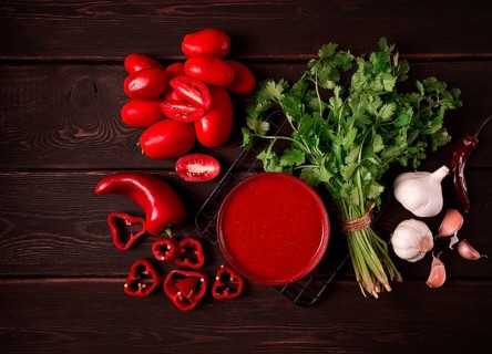 Tomato sauce, tomatoes and sweet pepper, Georgian Satsebeli sauce, with ingredients on a dark