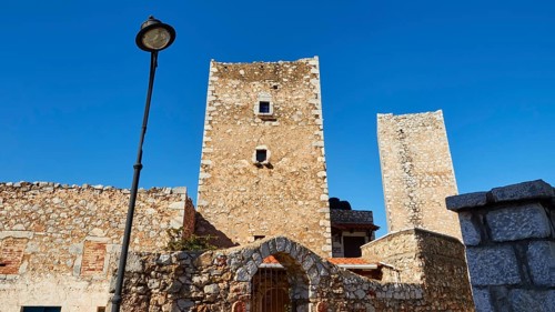 Historic stone towers next to a street lamp in a Mediterranean village, Flomochori, residential
