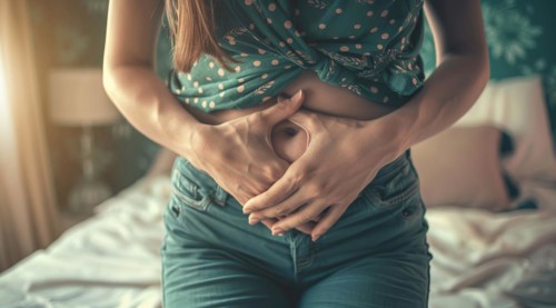A woman is holding her stomach, stomach pain during menstruation or constipation or other illness,