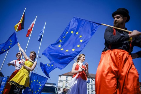 People pose with European flags on the occasion of the 'Ä®20th anniversary of Poland's accession to
