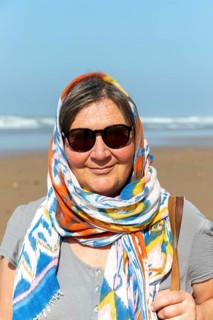 Middle aged woman on beach with sunglasses and head scarf, Morocco, north Africa, Model Released,
