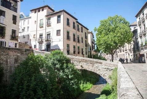 Historic buildings on Carrera del Darro and old bridge over the Rio Darro river, Granada, Spain,