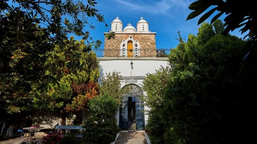 Church with white domes framed by trees and blue sky, Koroni, Byzantine fortress, nunnery,