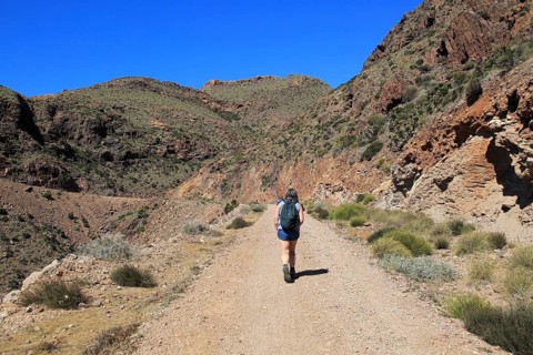 Woman walking along coast path in Cabo de Gata national park, near San José, Almeria, Spain, Europe