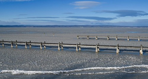 Frozen lake with ice and footbridge in winter, Lake Neusiedl, Podersdorf am See, Burgenland,