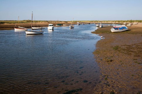 Boats in a tidal creek at Burnham Overy Staithe, north Norfolk coast, England, United Kingdom,