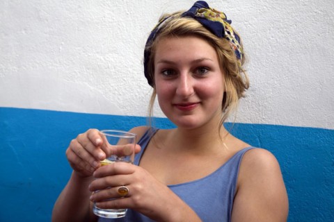 Model released portrait of teenage girl sitting holding a drink, UK