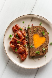 Breakfast, fried egg with bacon, micro-green, on a light background, no people, selective focus