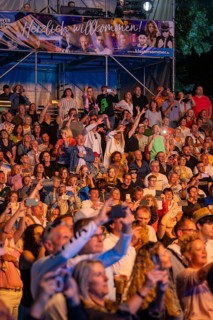 Crowd at night concert in front of stage with welcome banner, Klostersommer, Calw Hirsau, Black