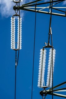 Insulators made of glass on a high-voltage line, they hang on the pylons as a suspension device