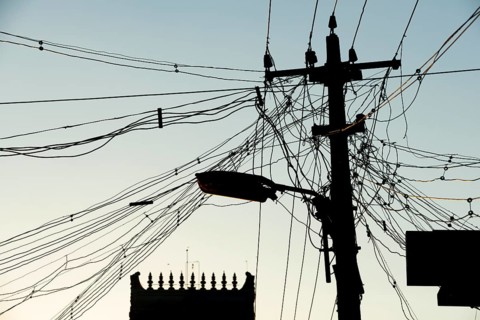 High-voltage power lines, tangle of cables, temple gopura or temple tower, Rameswaram or