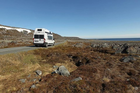 Campervan/caravan on a lonely coastal road through the tundra near Hamningberg on the Barents Sea,