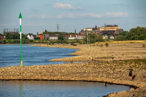 Low water on the Rhine at Duisburg-Homberg, view of Duisburg-Laar, houses on Deichstraße, gasometer
