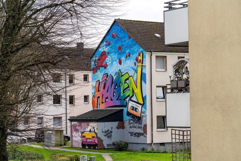 Housing estate, apartment buildings, colourful mural with local reference, music, 99 balloons, in