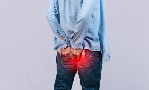 Man with digestive problem touching his buttock, man with hemorrhoid problem on isolated