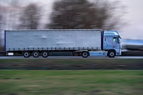 Truck, lorry, articulated lorry driving fast on the A92 motorway, motion blur, wiping effect,