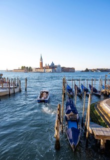 Water taxi and gondolas, San Giorgio Maggiore church in the background, evening light, Venice,